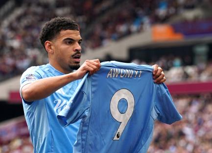Nottingham Forest players celebrating a goal while holding up a jersey with 