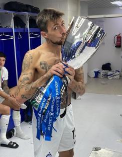 Man kissing a trophy in a locker room.
