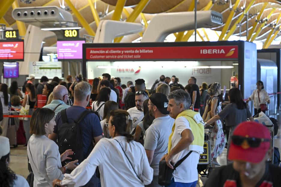 Long line of passengers at an Iberia airline customer service desk during a French air traffic controller strike.