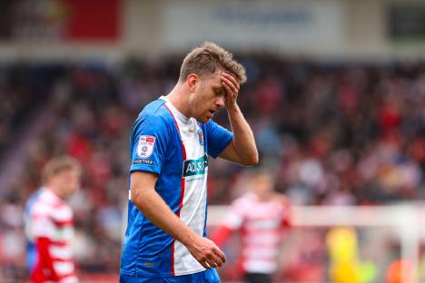 Archie Davies of Carlisle United looking dejected during a soccer game.