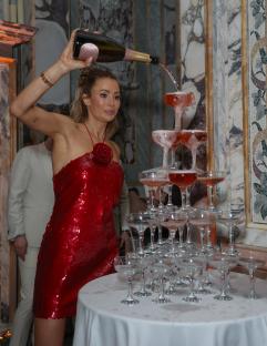 Woman pouring champagne into a champagne tower.
