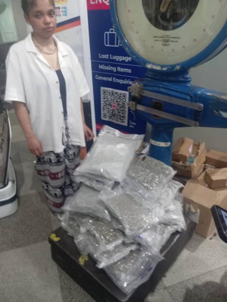 Taylor Tamara Simone, 21, stands next to a large quantity of drugs on a scale.