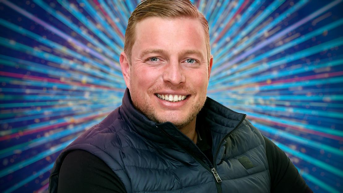 Portrait of a man smiling in front of a sparkly background.