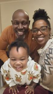 Photo of Jacqueline Shepherd, her partner David, and their child.