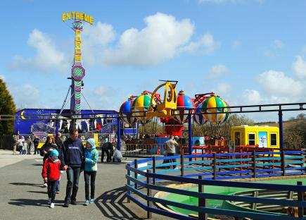 Family at a fun park with various rides.