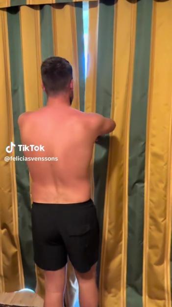 Man opening hotel room curtains.