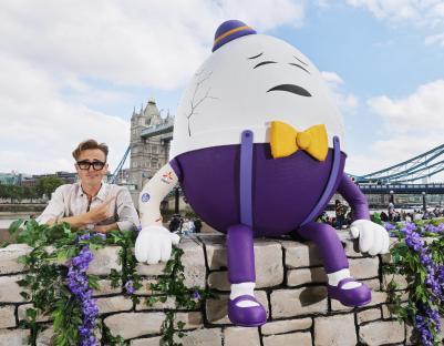 Tom Fletcher with a large Humpty Dumpty figure near the Tower Bridge.