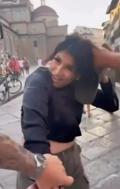 A man grabbing a woman's hair in a public place.