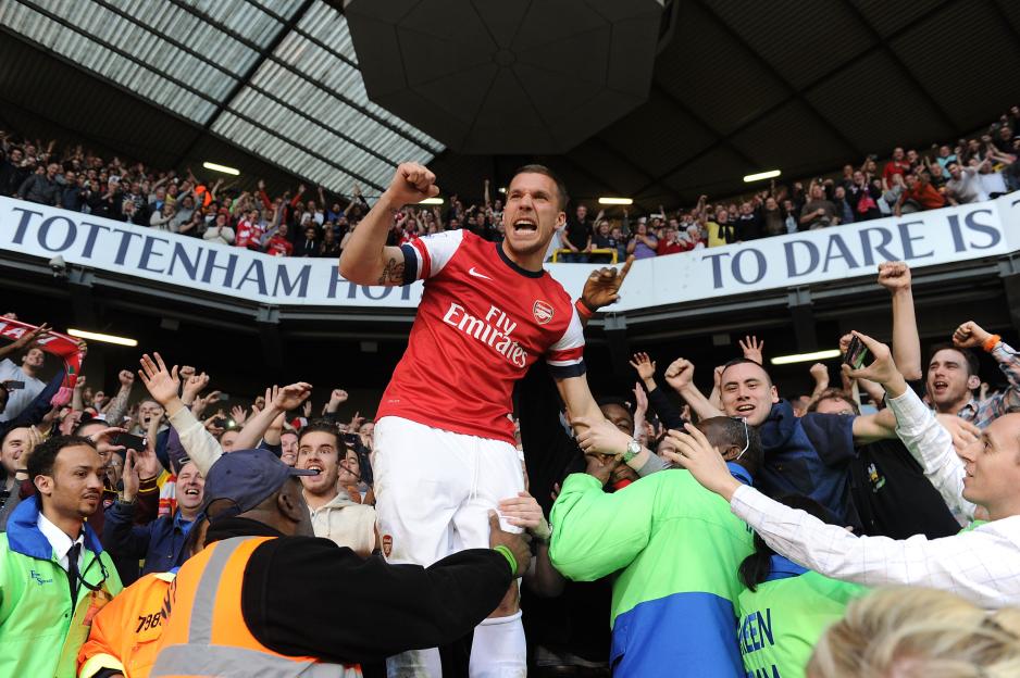 Lukas Podolski celebrates with Arsenal fans after a match.