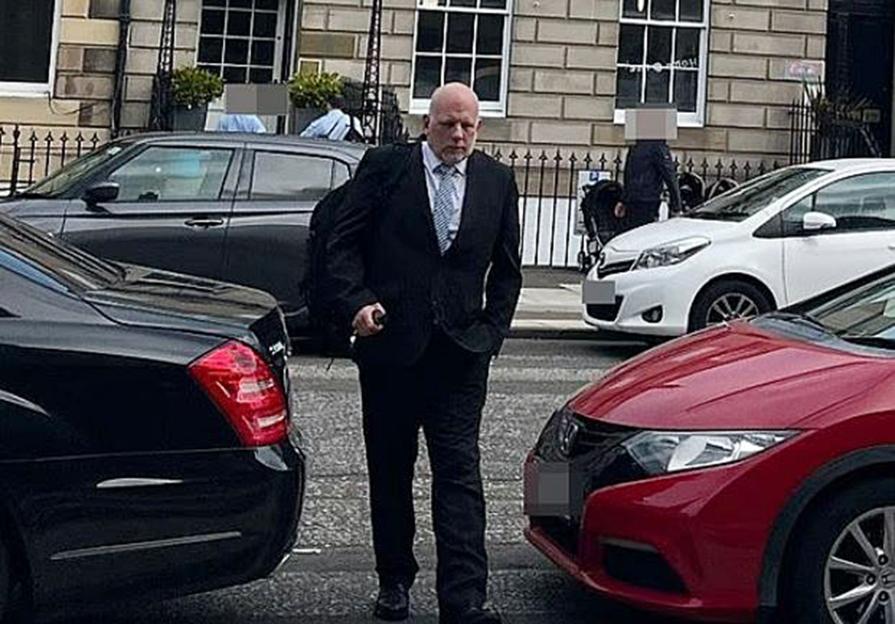 Man in suit walking down a street.