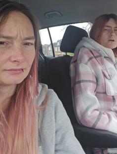 Two women in a car; one woman says