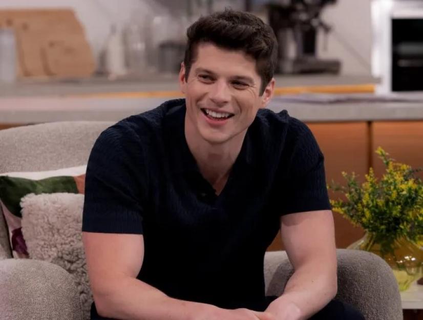 Man smiling while sitting on a couch.