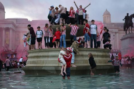 Sunderland fans celebrating in a fountain.
