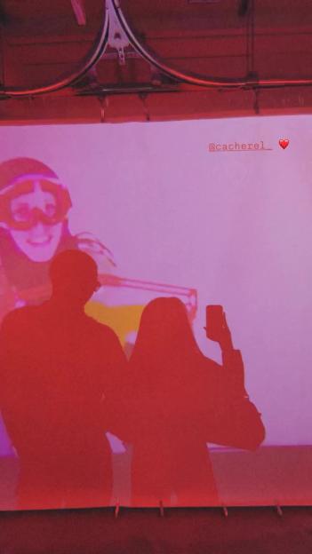 Silhouetted couple taking a photo in front of a projection.