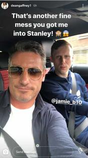 Two men in a car; one is taking a selfie.