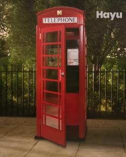Red telephone booth with door open.