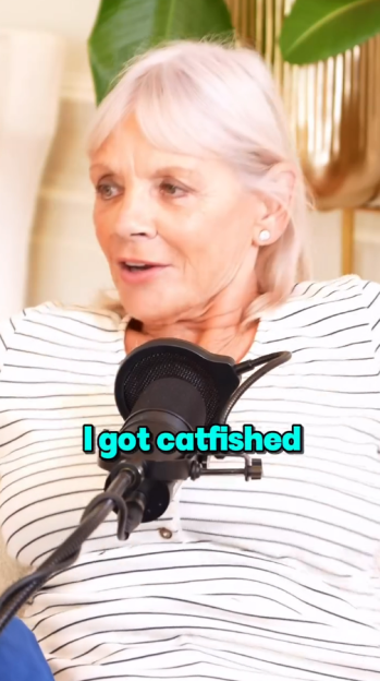 Woman with gray hair and a striped shirt speaking into a microphone with the text "I got catfished" on screen.