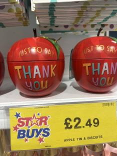 Two apple-shaped tins of biscuits that say 