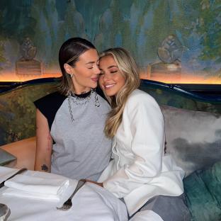 Two women embracing at a restaurant.