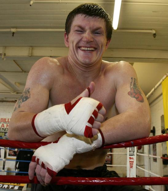 Ricky Hatton smiling and giving a thumbs-up in a boxing gym.