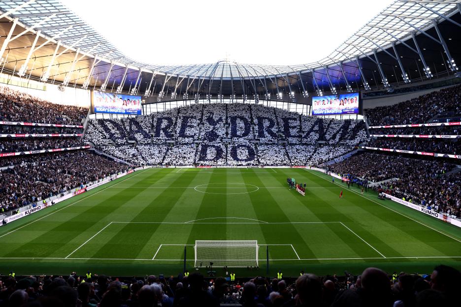 Stadium fans holding up signs that spell out "Dare Dream Do".