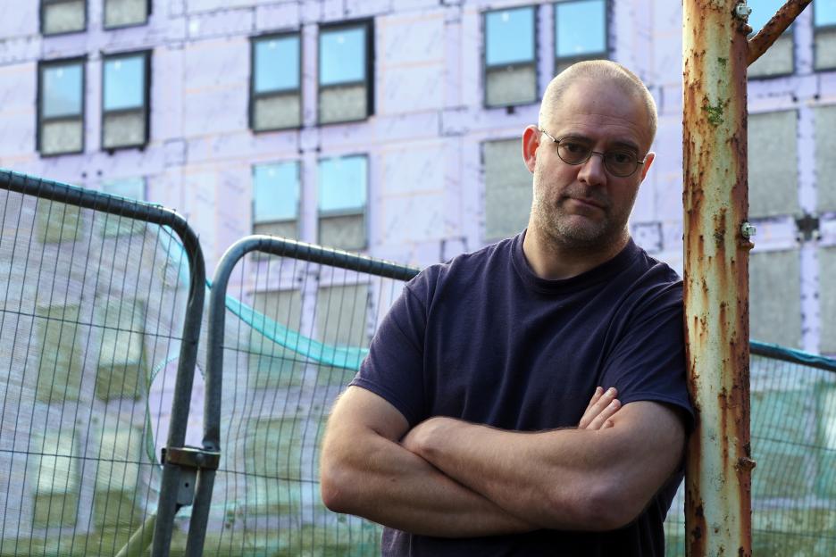 James Clewett standing in front of the abandoned student accommodation block.