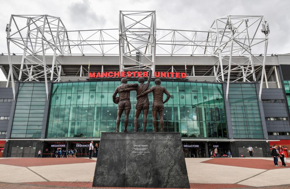 The Unity Trinity statue of George Best, Denis Law, and Bobby Charlton outside the Old Trafford football stadium.