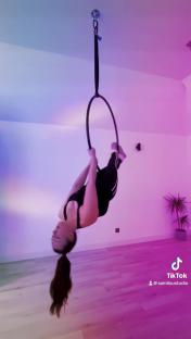 Woman upside down on an aerial hoop.