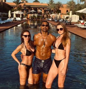 David Haye with two women in swimsuits in a pool.