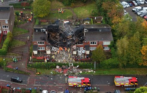 Aerial view of emergency responders at the scene of a destroyed house.