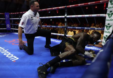 Deontay Wilder down on the mat during a boxing match.
