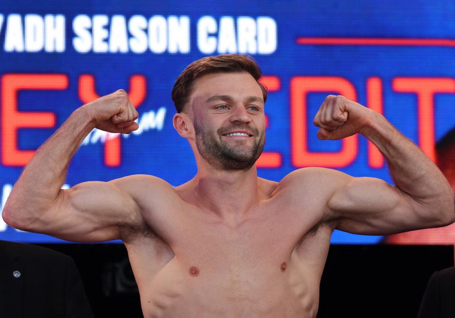 Josh Padley flexing his biceps at a boxing weigh-in.