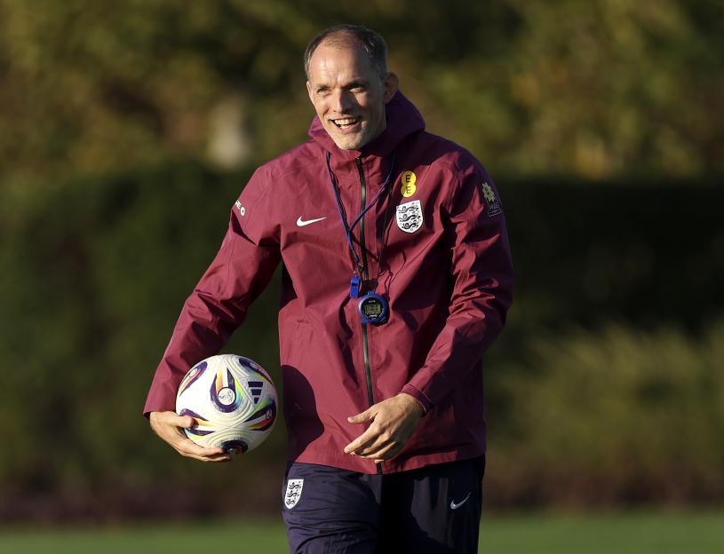 Thomas Tuchel, Head Coach of England, smiles while holding a soccer ball.