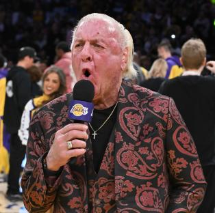 Ric Flair speaking into a Los Angeles Lakers microphone.