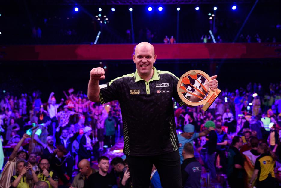 Michael van Gerwen holding a trophy after winning a darts tournament.