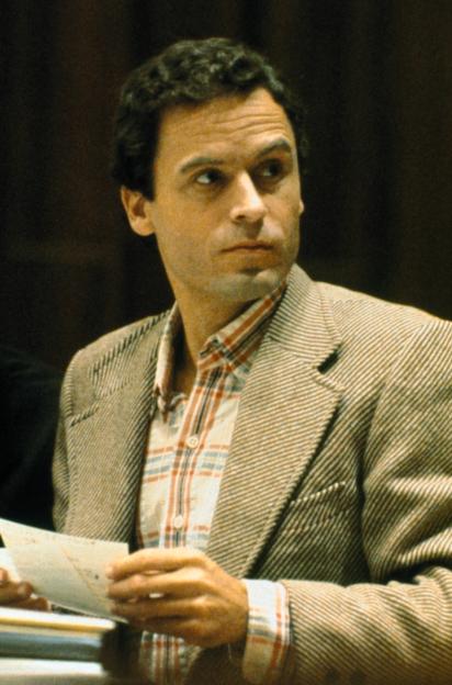Theodore Bundy in a light brown suit jacket over a plaid shirt, looking to his right during his trial.