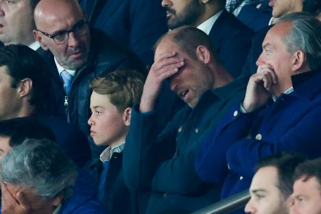 Prince William, Prince George, and others watching a sporting event.