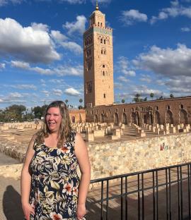 Woman in floral dress in front of a minaret in Marrakesh.