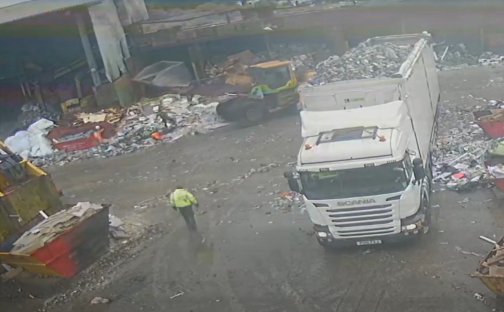 Aerial view of a scrapyard with a truck being loaded with scrap metal.