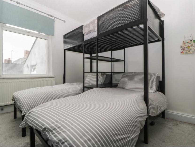 Bedroom with a bunk bed, a single bed, and a window.