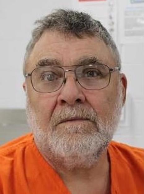 Mugshot of a 65-year-old man in an orange jumpsuit.
