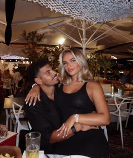 Couple sitting close together at an outdoor restaurant.