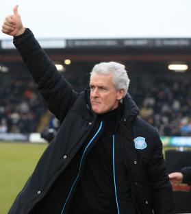 Mark Hughes, Carlisle United manager, giving a thumbs-up to fans.