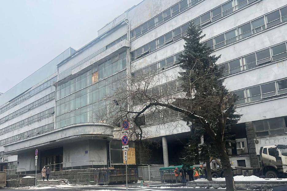 Pravda publishing house in Moscow, a multi-story building with many windows and trees in front.