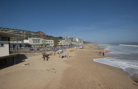 Boscombe beach in Bournemouth, with buildings and people on the sand.