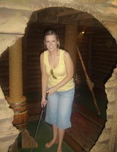 Woman playing miniature golf.