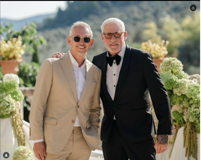 Two men in suits at an outdoor event.