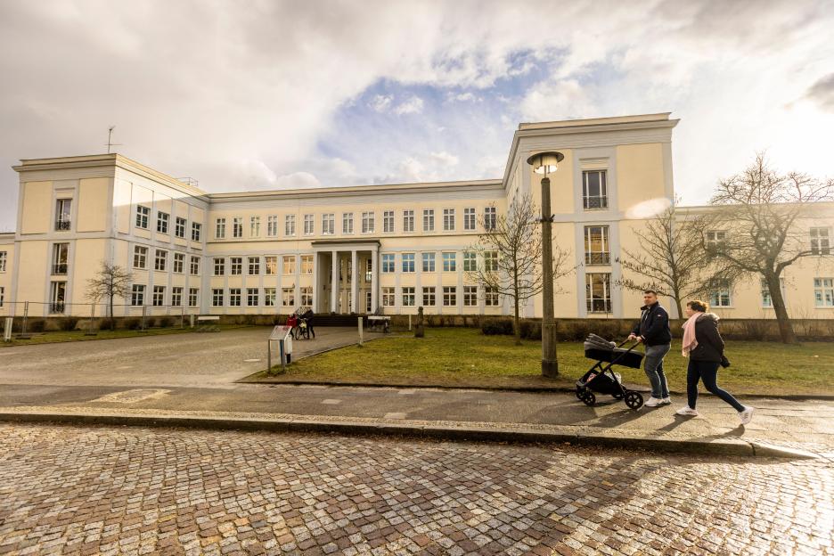A couple walks past an elementary school in Eisenhuttenstadt, Germany.