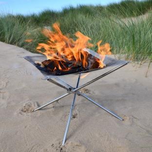 Portable mesh fire pit on a beach.