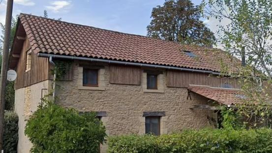 Stone house with brown tile roof.